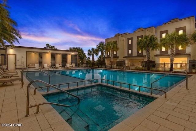 pool at dusk with a patio area