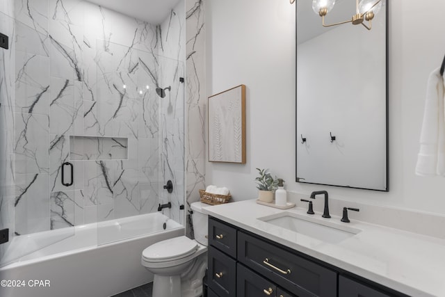 full bathroom featuring an inviting chandelier, vanity, tiled shower / bath combo, and toilet