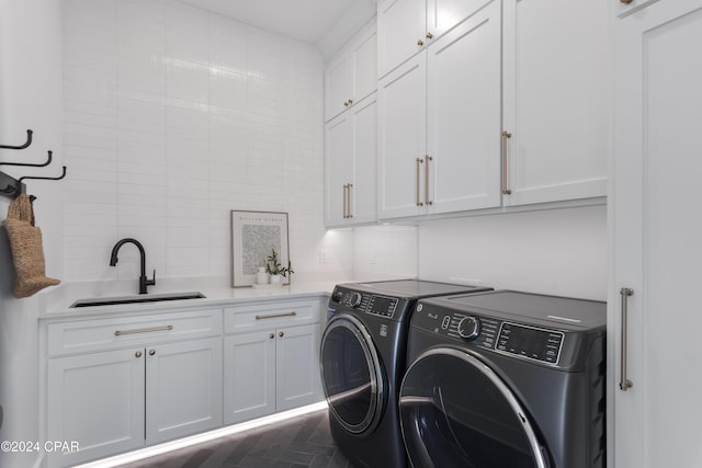 clothes washing area featuring dark parquet flooring, separate washer and dryer, sink, and cabinets