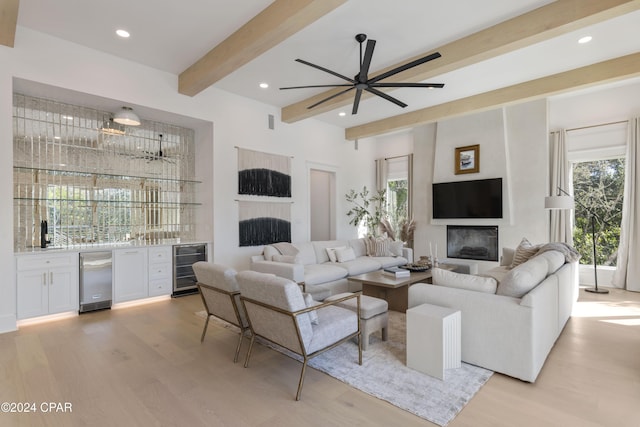 living room with beamed ceiling, ceiling fan, light hardwood / wood-style floors, and wine cooler