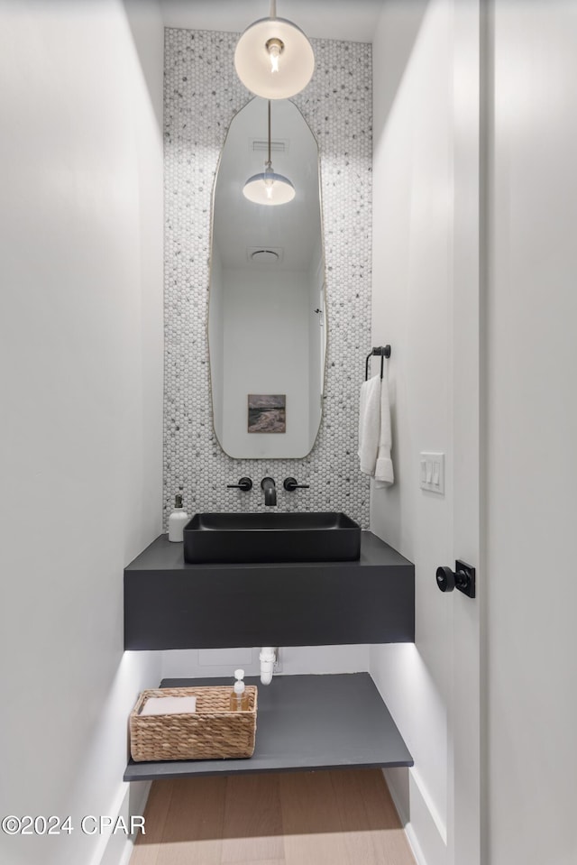 bathroom with tasteful backsplash, vanity, tile walls, and hardwood / wood-style flooring