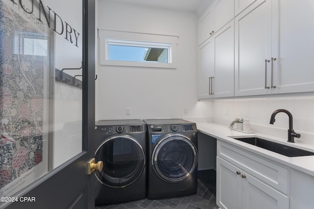 washroom featuring cabinets, sink, and washer and dryer