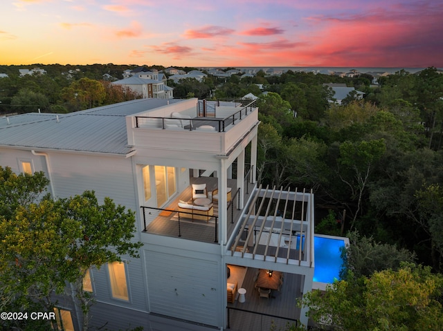 back house at dusk with a balcony