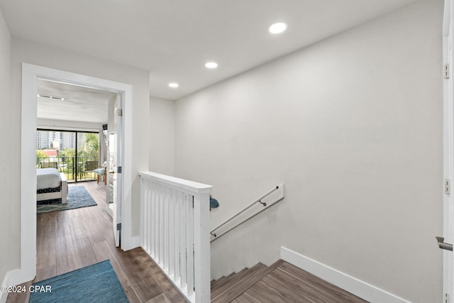 staircase featuring wood-type flooring and baseboard heating