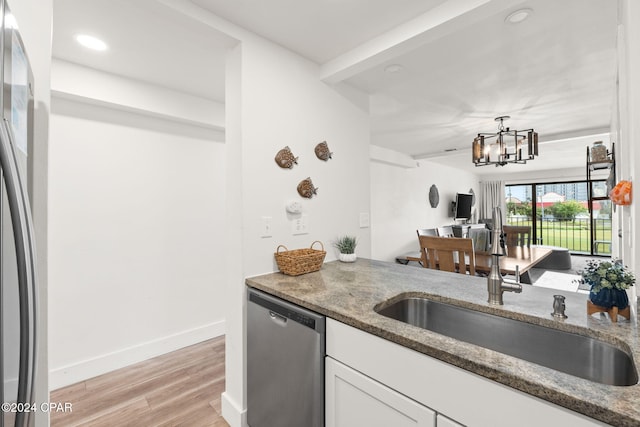 kitchen featuring an inviting chandelier, sink, light hardwood / wood-style flooring, stainless steel dishwasher, and white cabinetry