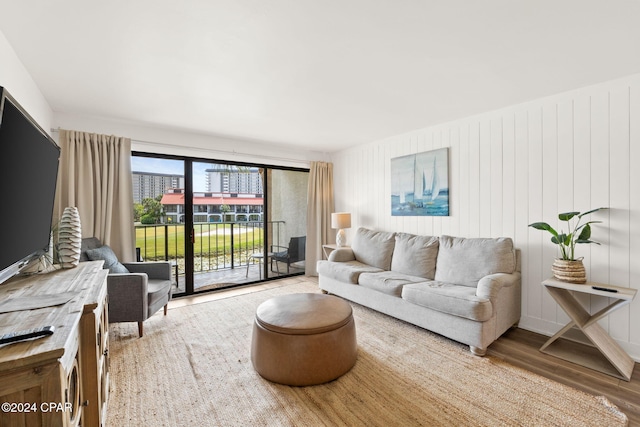 living room with hardwood / wood-style flooring and wood walls