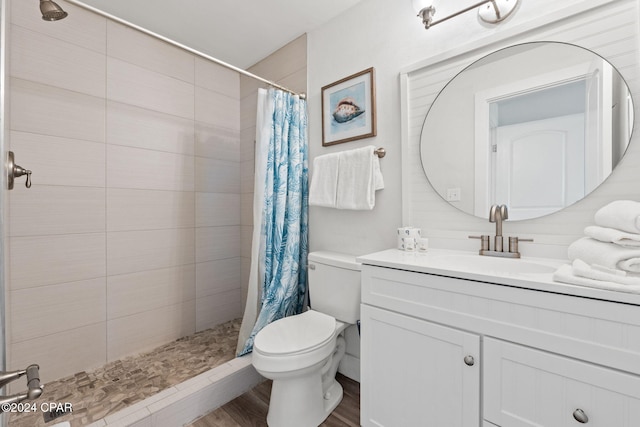 bathroom featuring hardwood / wood-style floors, a shower with curtain, toilet, and vanity