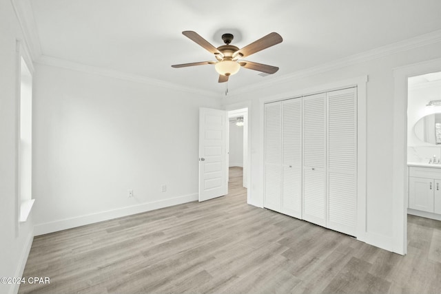 unfurnished bedroom with ensuite bath, a closet, ornamental molding, light wood-type flooring, and ceiling fan