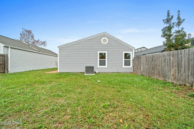 back of property with a lawn and central air condition unit