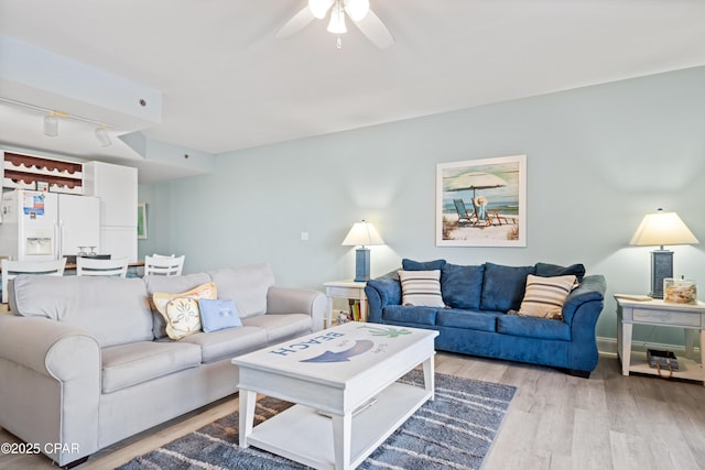 living room featuring ceiling fan and light hardwood / wood-style flooring