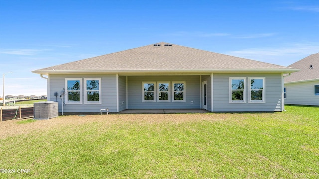 back of property featuring cooling unit and a yard