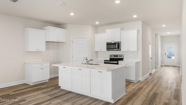 kitchen featuring dishwasher, white cabinets, a center island with sink, sink, and light hardwood / wood-style flooring