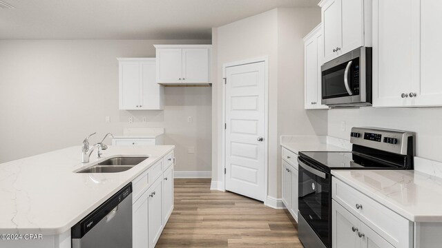 kitchen with a kitchen island with sink, white cabinets, stainless steel appliances, and wood-type flooring