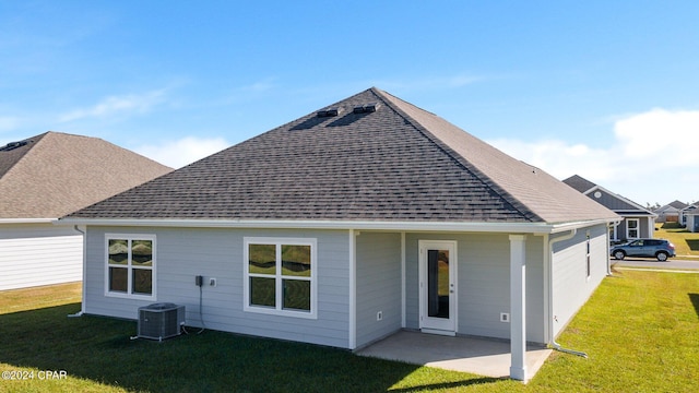 rear view of house featuring a yard, central AC, and a patio area