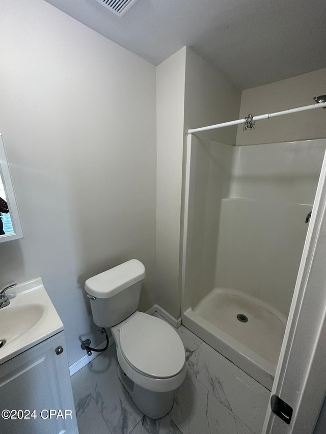 bathroom with a shower, vanity, and toilet