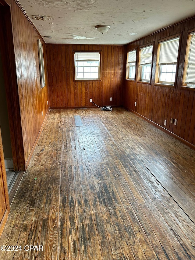 empty room with dark wood-type flooring and wooden walls