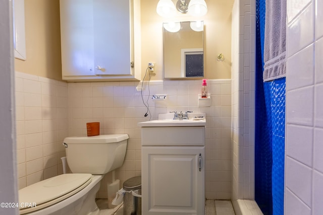 bathroom featuring curtained shower, vanity, tile walls, and toilet