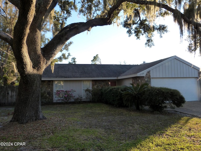 ranch-style house featuring a garage and a front yard