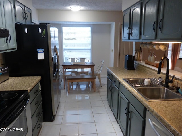 kitchen with stainless steel dishwasher, a textured ceiling, sink, black electric range, and light tile patterned flooring