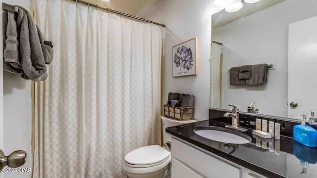 bathroom featuring a shower with curtain, vanity, and toilet