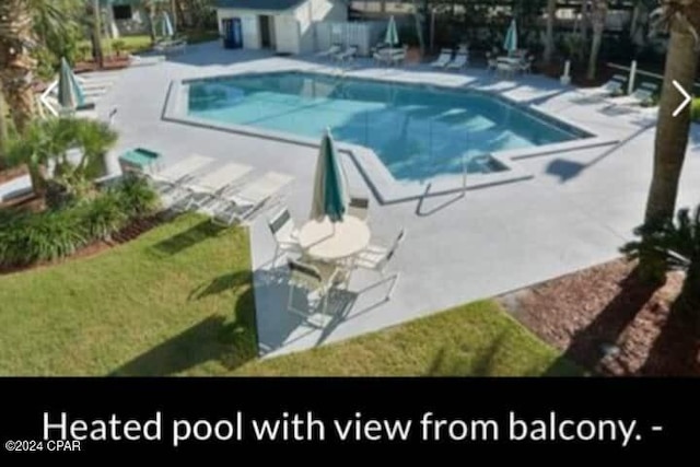 view of swimming pool with a patio area, a yard, and an outdoor structure