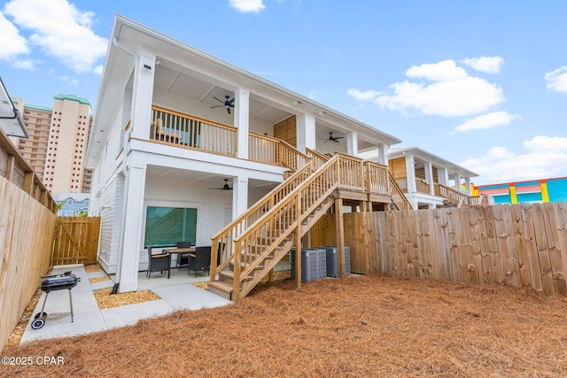 back of house featuring a balcony, ceiling fan, a fenced backyard, stairway, and a patio area