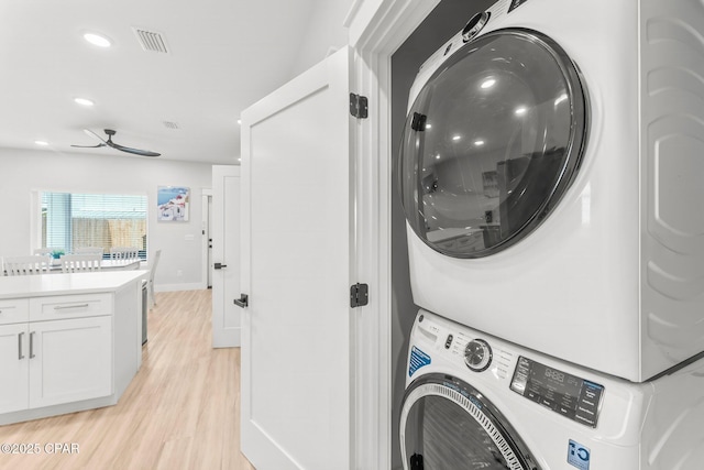 laundry room with laundry area, visible vents, stacked washer / dryer, light wood-style flooring, and recessed lighting