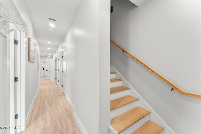 hallway featuring light wood-style flooring, recessed lighting, visible vents, baseboards, and stairway