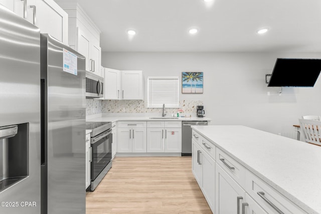 7026 Thomas Dr Unit A & B, Panama City Beach, FL 32408 - kitchen featuring stainless steel appliances, white cabinets, light wood finished floors, light countertops, and recessed lighting