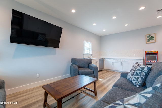 living room featuring light wood-type flooring and sink