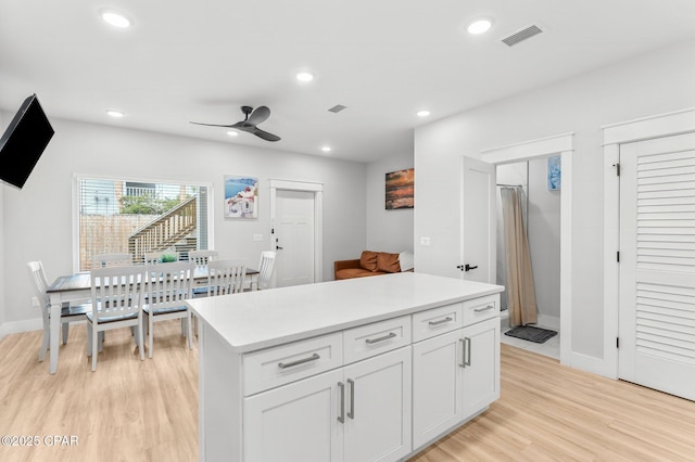 kitchen with light wood finished floors, recessed lighting, light countertops, visible vents, and white cabinetry