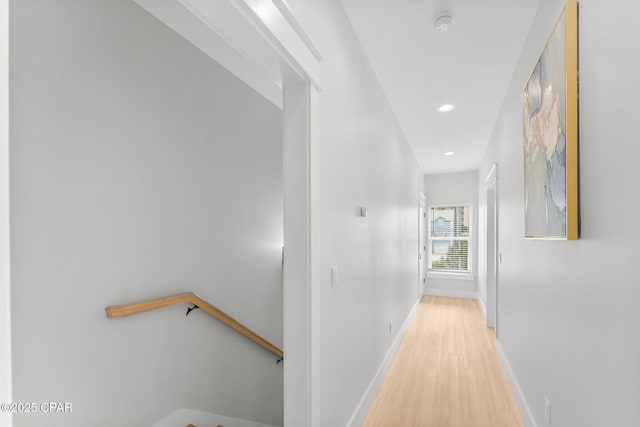 hallway with light wood-style floors, baseboards, and recessed lighting