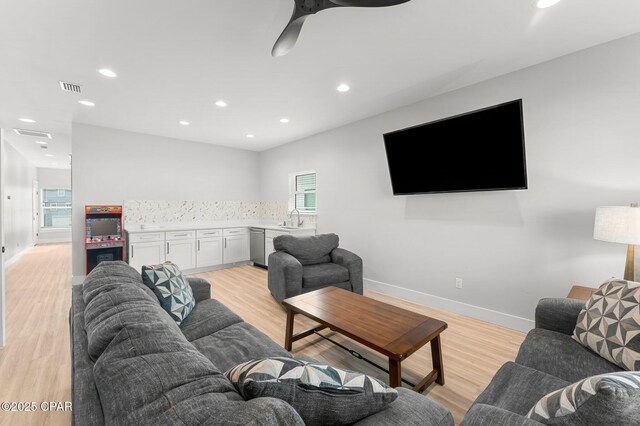 washroom with light hardwood / wood-style flooring and stacked washer and clothes dryer