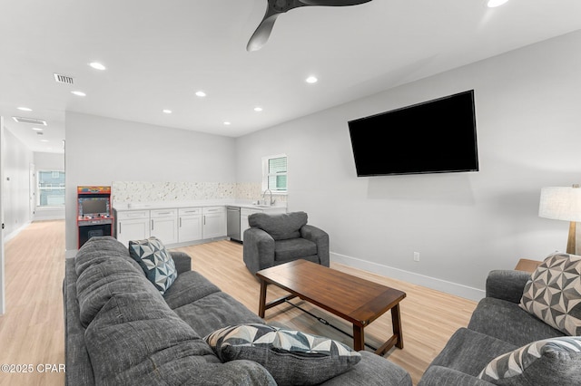 living room with light wood-type flooring, baseboards, visible vents, and recessed lighting