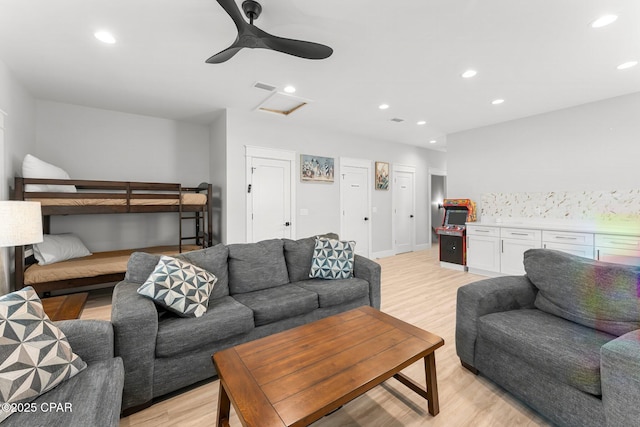 living area featuring visible vents, light wood-type flooring, attic access, and recessed lighting