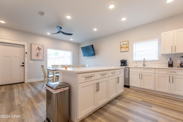 kitchen featuring a center island, white cabinets, light hardwood / wood-style flooring, decorative backsplash, and ceiling fan