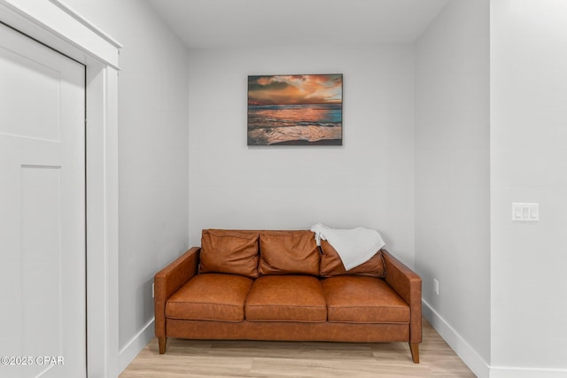 living area with light wood-type flooring and baseboards