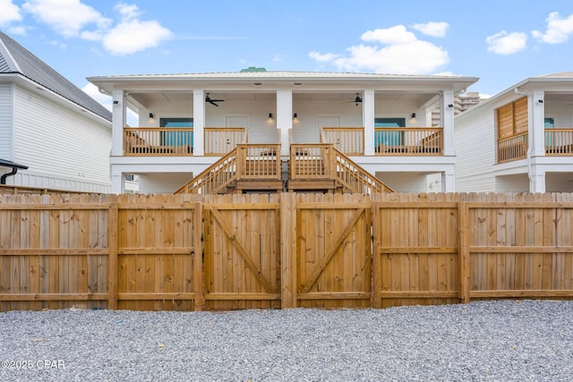 view of gate featuring stairs, fence, and a ceiling fan