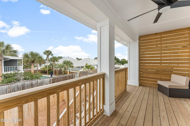 wooden terrace featuring ceiling fan and fence