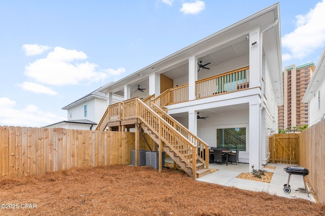 rear view of property featuring a ceiling fan, a patio, a balcony, a fenced backyard, and stairway