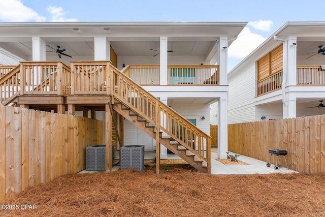 back of property featuring stairway, a ceiling fan, and central air condition unit