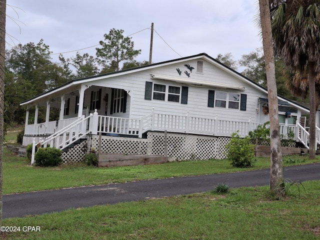 view of front of property with a porch and a front lawn