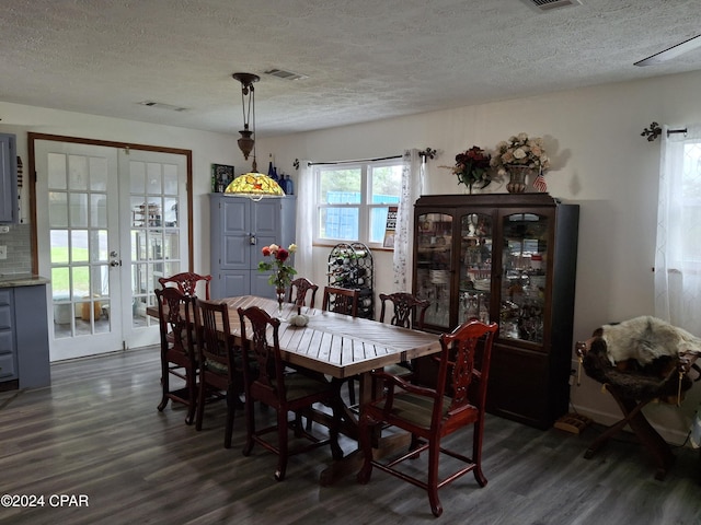 dining room featuring french doors, a textured ceiling, and dark wood-type flooring