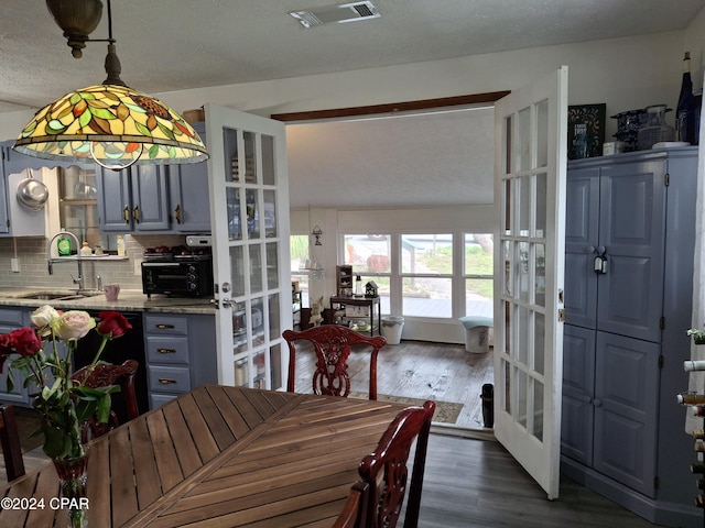 dining space with a textured ceiling, dark hardwood / wood-style floors, sink, and french doors