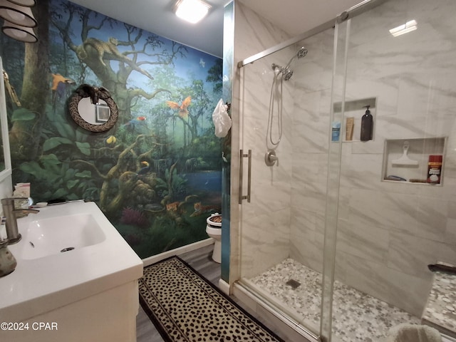 bathroom with an enclosed shower, vanity, toilet, and hardwood / wood-style flooring