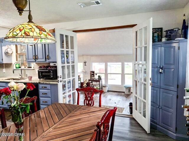 dining room featuring a toaster, visible vents, dark wood-type flooring, and french doors