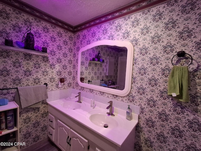 bathroom with vanity, crown molding, and a textured ceiling