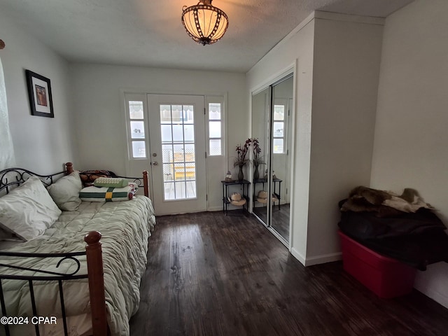 bedroom featuring dark hardwood / wood-style flooring, a textured ceiling, and a closet