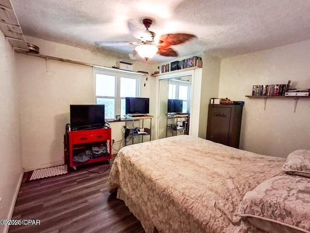 bedroom with dark wood-style floors, ceiling fan, baseboards, and a textured ceiling