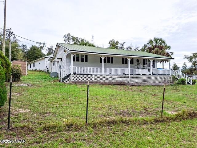 back of house featuring a wooden deck and a yard